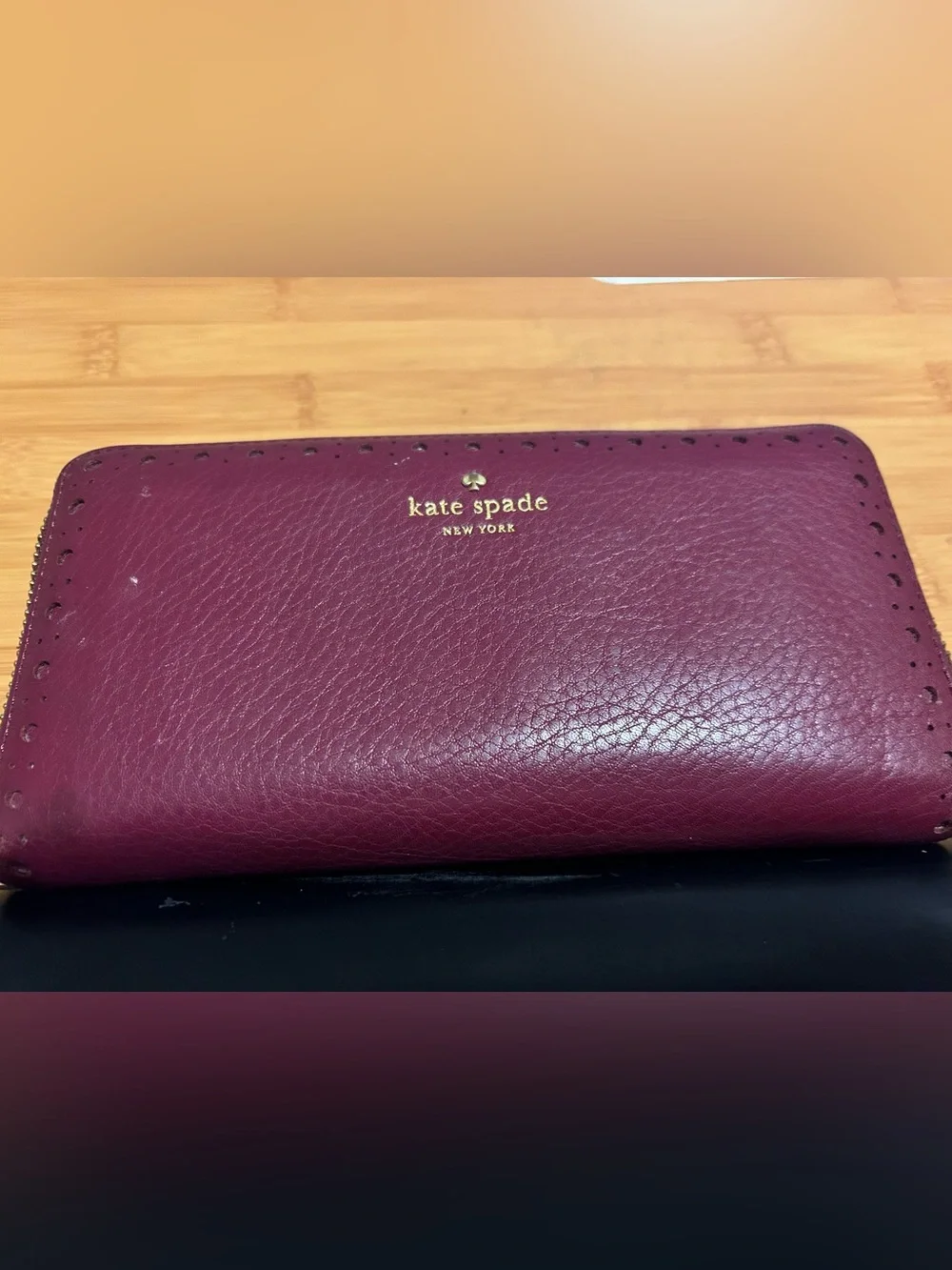 Kate Spade burgundy wallet with multiple pockets & card slots & zipper inside.